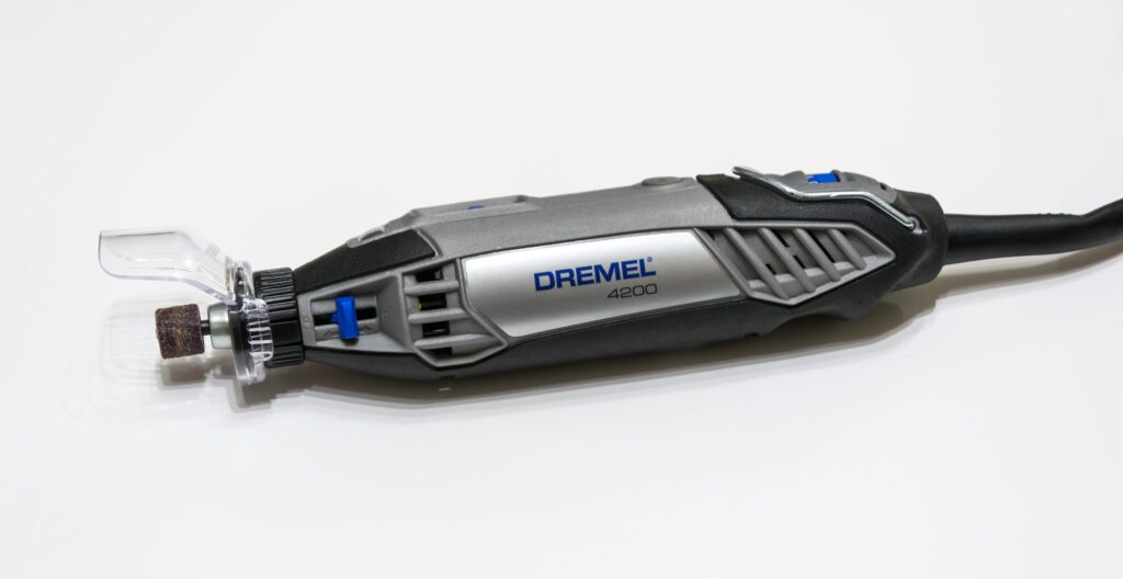 Dremel 4200, herramienta rotativa multiuso. Vista lateral de la herramienta, el cable de alimentación y algunos de sus accesorios en un maletín, destacando el sistema de cambio rápido EZ Change